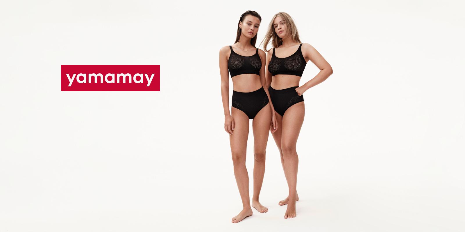Yamamay Teams Up with Centric Software to Strengthen Sustainability and Power Innovation Featured Two women stand side by side against a white background, both wearing black bralettes and high-waisted underwear. They are barefoot and looking directly at the camera. The word "yamamay" is displayed in bold, white letters on a red rectangular background to the left, highlighting their brand's LAN connection in fashion innovation.