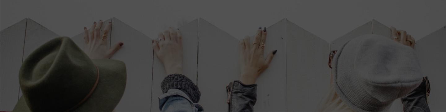 Séminaire Lyon : le PLM comme vecteur d’innovation dans la Mode, le Sport et la Distribution Plusieurs mains posées sur un mur blanc, avec des personnes portant différents chapeaux visibles de dessus.